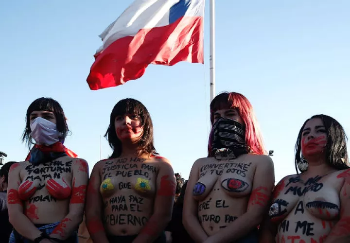 Mujeres participan en la intervención feminista Un violador en tu camino frente al Estadio Nacional en Santiago. EFE.