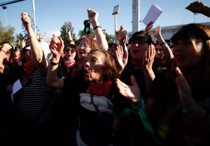 Mujeres participan en la intervención feminista Un violador en tu camino frente al Estadio Nacional en Santiago. EFE.