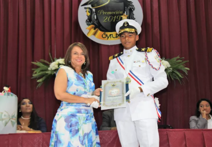 La ministra de Educación, Maruja Gorday de Villalobos, hace entrega del diploma a uno de los estudiantes. 