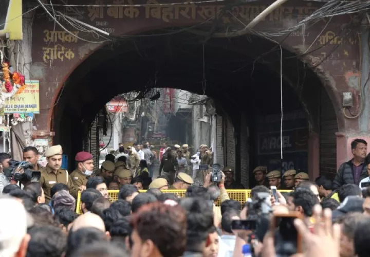 La policía y los periodistas indios se encuentran cerca del sitio donde estalló un incendio en Nueva Delhi. FOTO/AP