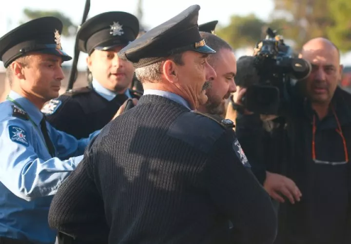 El primer ministro de Malta,  Joseph Muscat, es sacado rápidamente del Parlamento, en medio de una protesta en su contra. FOTO/AP