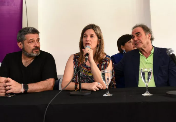 El director estadounidense Oliver Stone (derecha); la rectora de la UMET, Cecilia Cross; y el presidente del Grupo Octubre, Víctor Santa María, en el acto en Buenos Aires. Foto: EFE.