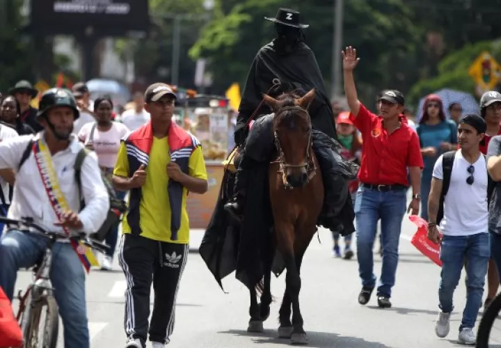 Un hombre caracterizado como el personaje 'El Zorro' participa en una marcha como parte de la tercera jornada de "paro nacional" contra el Gobierno del presidente Iván Duque para rechazar sus políticas económicas y sociales. FOTO/EFE
