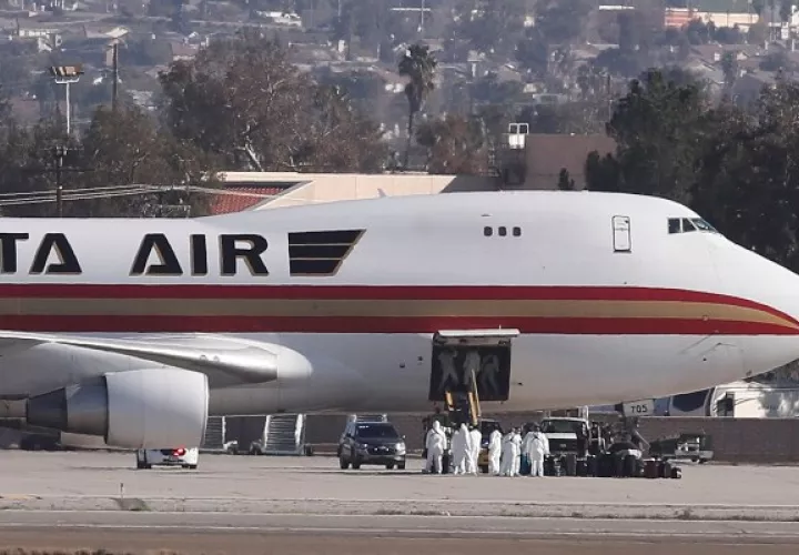 Las imágenes aéreas mostraron el avión proveniente de China estacionado en la mitad de la pista con la escalera extendida sin que los pasajeros descendieran inmediatamente. FOTO/AP