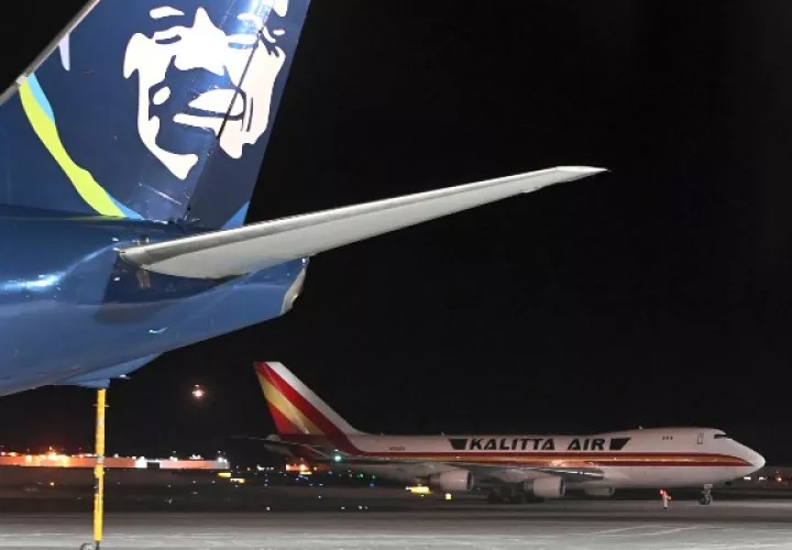 Un avión, de fondo, que transporta a ciudadanos estadounidenses que fueron evacuados de Wuhan la ciudad más afectada por el coronavirus,hace una parada de reabastecimiento de combustible en la terminal norte del Aeropuerto Internacional Ted Stevens Anchorage