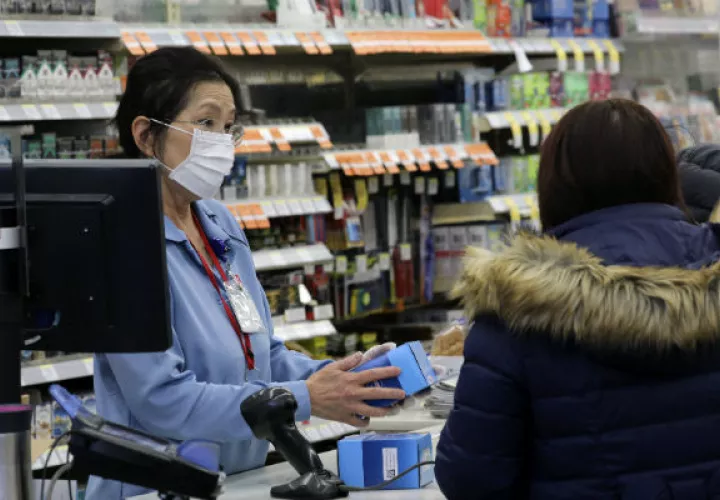 En Wuhan, la gente compra mascarillas, gafas protectoras y batas para protegerse. Foto: AP. 