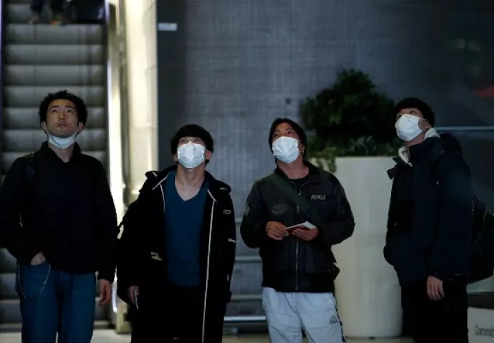  Los pasajeros usan máscaras faciales cuando llegan al aeropuerto de Roissy, en las afueras de París, Francia. FOTO/AP