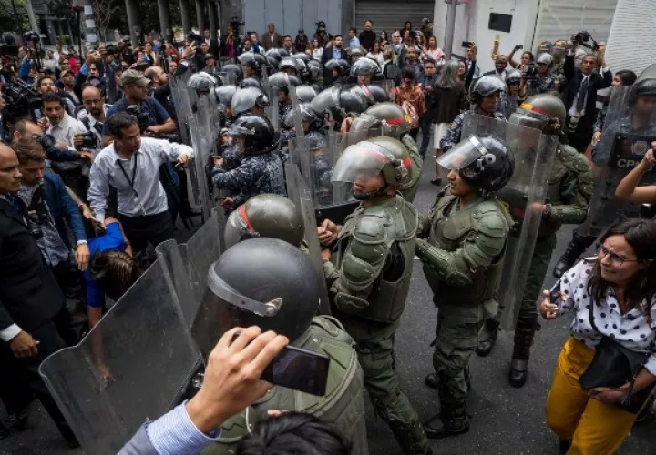 Opositores venezolanos lucha contra la Policía para poder ingresar a la Asamblea Nacional. FOTO/EFE