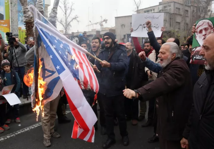  Los iraníes queman banderas estadounidenses e israelíes durante las protestas antiestadounidenses por el asesinato del difunto teniente general del Cuerpo de la Guardia Revolucionaria iraní (IRGC) y comandante de la Fuerza, Qassem Soleimani, en Teherán. Foto EFE