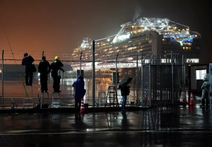 Un grupo de periodistas espera la salida de los buses con pasajeros del crucero que serían llevados a centros hospitalarios. FOTO/AP