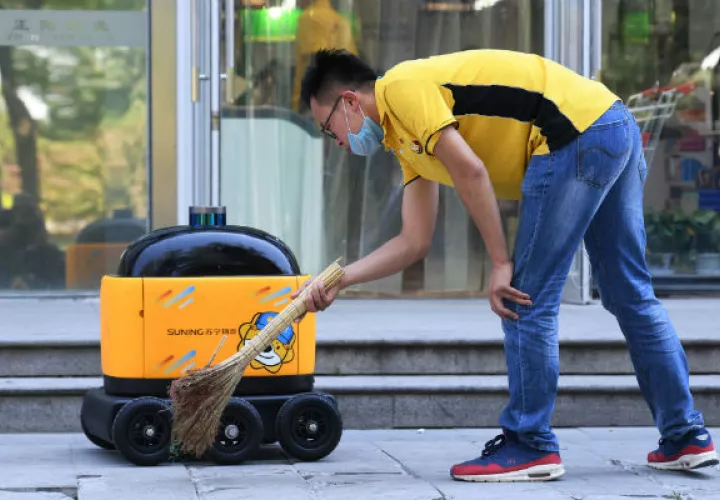 Expertos dicen que la tecnología ha evitado la recesión en China. Un robot repartidor afuera de un supermercado en Beijing. Foto / Greg Baker/Agence France-Presse — Getty Images.