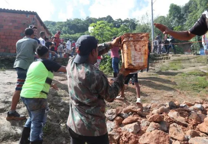 habitantes y bomberos buscando a los desaparecidos tras el derrumbe en el "Morro do Macaco Molhado", en Guarujá (Brasil). FOTO/EFE
