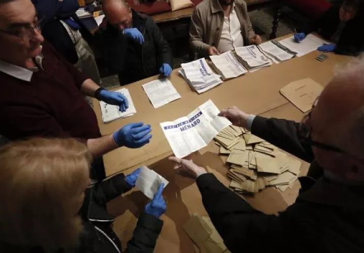 Los funcionarios que usan guantes cuentan las papeletas emitidas durante la primera vuelta de las elecciones municipales francesas en un colegio electoral, en Béziers, Francia. FOTO/EFE