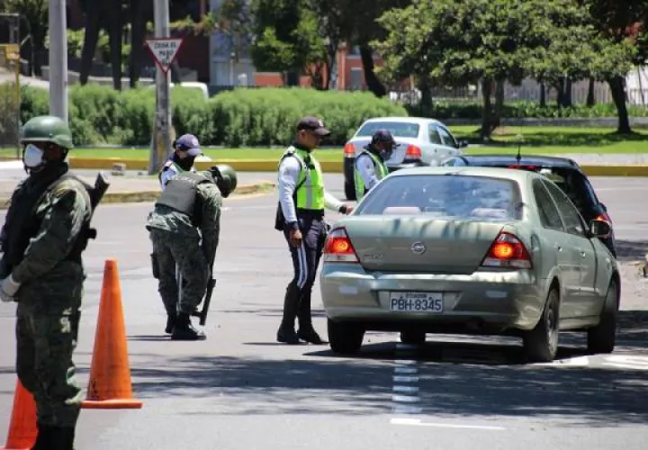 Agentes de la Policía Metropolitana de Quito y soldados del Ejército ecuatoriano controlan uno de los accesos a la ciudad para hacer cumplir las restricciones de circulación dentro del paquete de medidas para evitar la propagación del COVID-19. FOTO/EFE