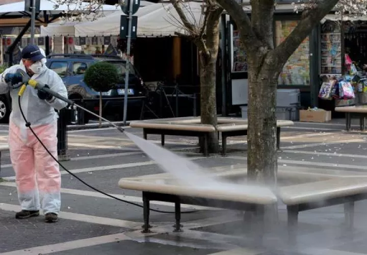 Varios operarios trabajan en la limpieza para evitar la propagación del coronavirus, en la plaza de la Estación Central de Milán. FOTO/EFE