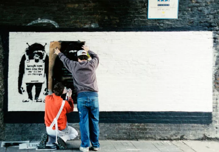 Banksy (izq.) y un asistente hacen un stencil en la calle Rivington en Londres a principios de los años 2000. Foto / Steve Lazarides.