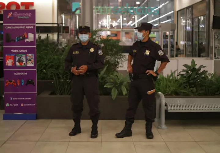 Fuerzas de seguridad vigilan un centro comercial cerrado en San Salvador. Foto: EFE.