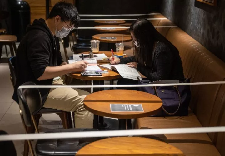 Un Starbucks en Hong Kong refuerza el distanciamiento social al no dar acceso a ciertas sillas y mesas. Foto / Jerome Favre/EPA, vía Shutterstock.