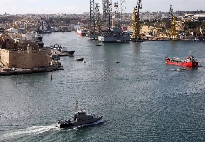 Un barco mercante (der.) en Malta en el 2019 luego de que migrantes tomaran el control para no ser devueltos a Libia. Foto / Anne Aquilina/EPA, vía Shutterstock.