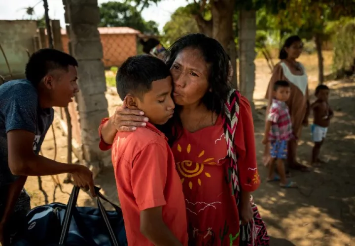 Aura Fernández besa a su hijo antes de dejar Venezuela. “Te amo”, dijo antes de irse. “Estudien mucho”. Foto / Meridith Kohut para The New York Times.