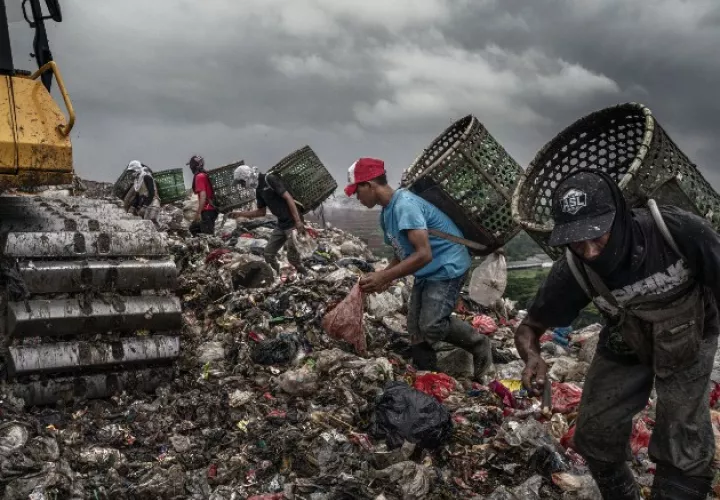 Recicladores y niños desde los 5 años buscan basura reutilizable junto a máquinas grandes y peligrosas. Foto / Adam Dean para The New York Times.