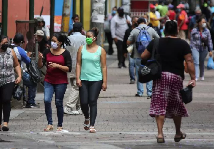Mujeres con tapabocas caminan por la Calle Peatonal. EFE