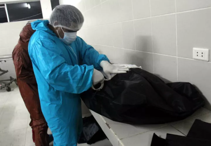 Un empleado de la morgue del Hospital Pampa de la Isla en Santa Cruz (Bolivia), prepara un cadáver. Fotos: EFE.