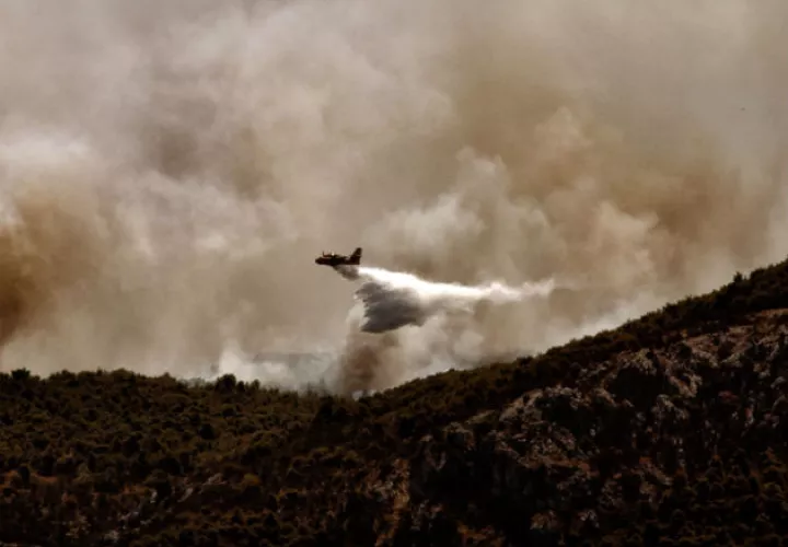 Un hombre observa su vivienda arrasada por el incendio forestal. Fotos: EFE.