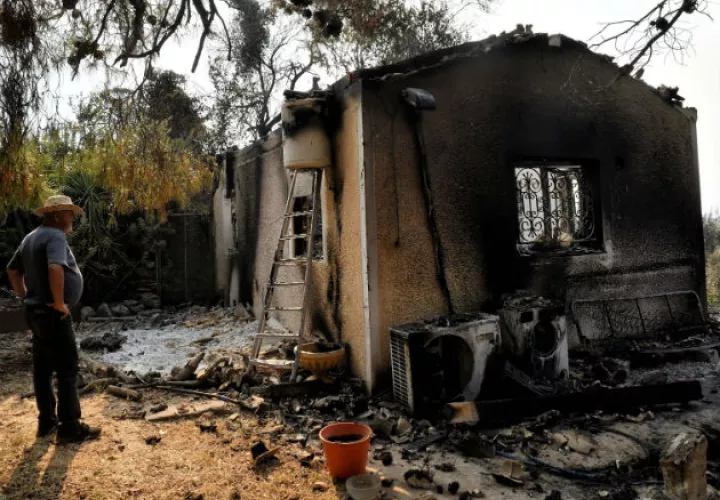 Un hombre observa su vivienda arrasada por el incendio forestal. Fotos: EFE.