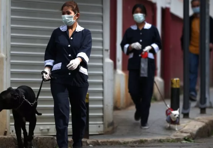 Cientos de miles de sirvientas y niñeras extranjeras laboran en países árabes. Paseadoras de perros en Beirut. Foto / Patrick Baz/Agence France-Presse — Getty Images.