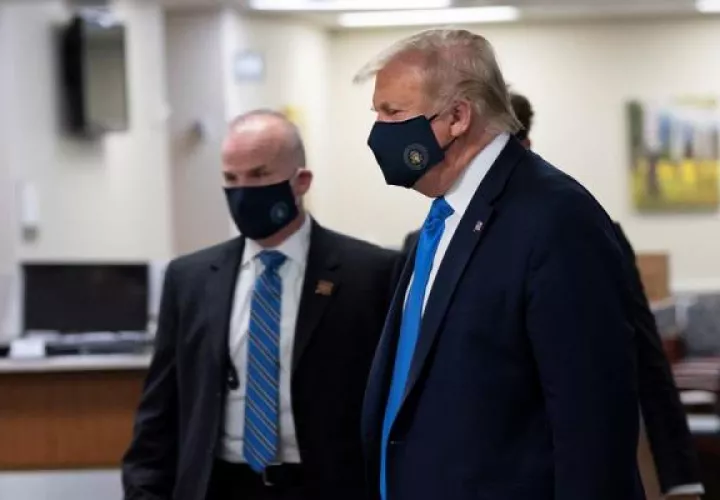 Cuando Trump fue visto este sábado con mascarilla, intentó ofrecer una imagen de fortaleza: iba rodeado de militares y miembros del servicio secreto que no se detuvieron ni un minuto ante las cámaras mientras el mandatario, al frente, dirigía el rumbo de la comitiva. FOTO/EFE