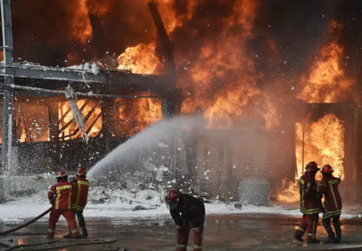 Un helicóptero de la armada lanza agua al fuego en el puerto de Beirut (Líbano). Fotos:EFE.