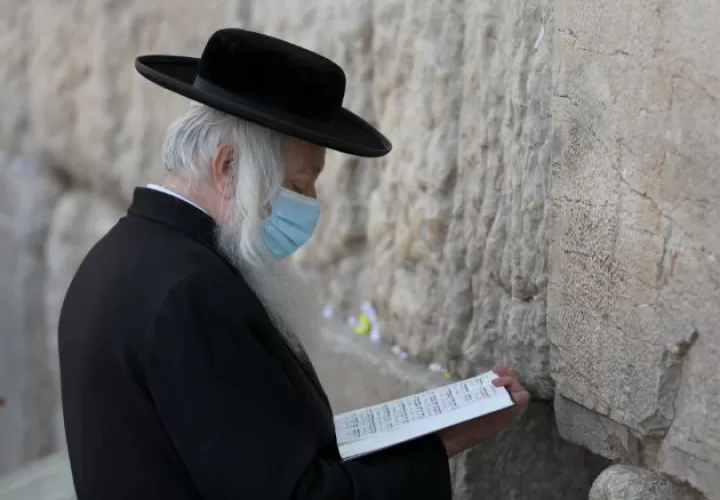 Judíos ortodoxos oran en el muro al oeste de la vieja ciudad de Jerusalén, a dos días de reiniciar el aislamiento total por el coronavirus. EFE.