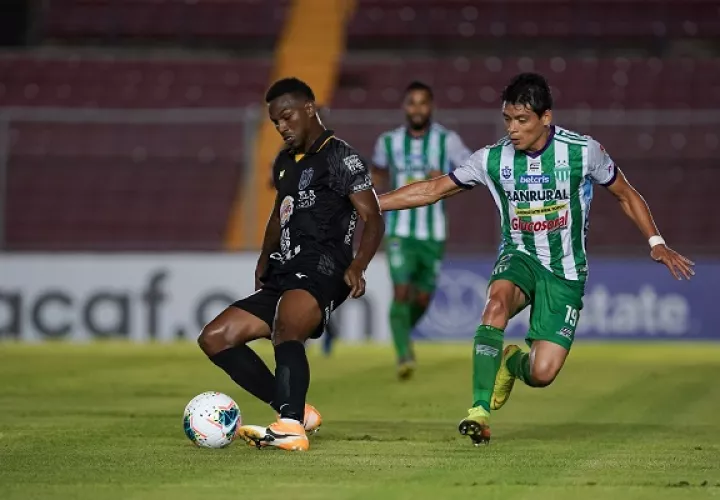 Omar Browne (izq.) protege el balón ante Robin Betancourth de Antigua. Foto:EFE