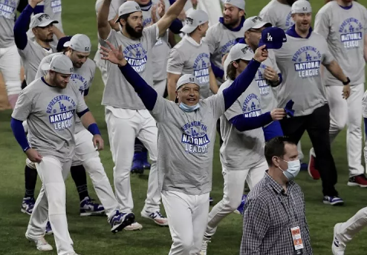 El director Dave Roberts (cent.) festeja el título de la Liga Nacional de los Dodgers. Foto:EFE