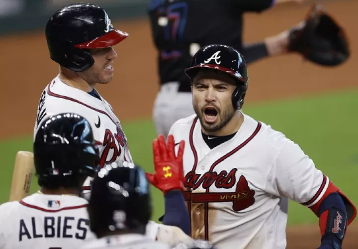 Travis d'Arnaud  de los Bravos (der.) festeja su jonrón: Foto:EFE