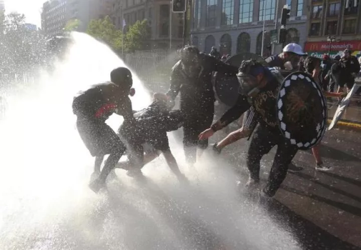 Manifestantes enfrentan a los carabineros durante una nueva jornada de protestas antigubernamentales. EFE