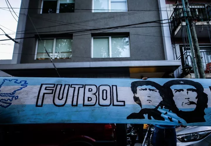 Fanáticos del exfutbolista y entrenador argentino Diego Armando Maradona despliegan una bandera en su honor afuera de clínica donde será operado. Foto:EFE 