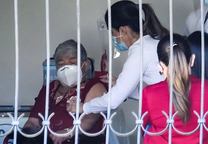 Personal del ministerio de Salud atiende a Elizabeth Castillo, quien fue la primera persona en ser vacunada contra la COVID-19 en Costa Rica, el 24 de diciembre. Foto: EFE