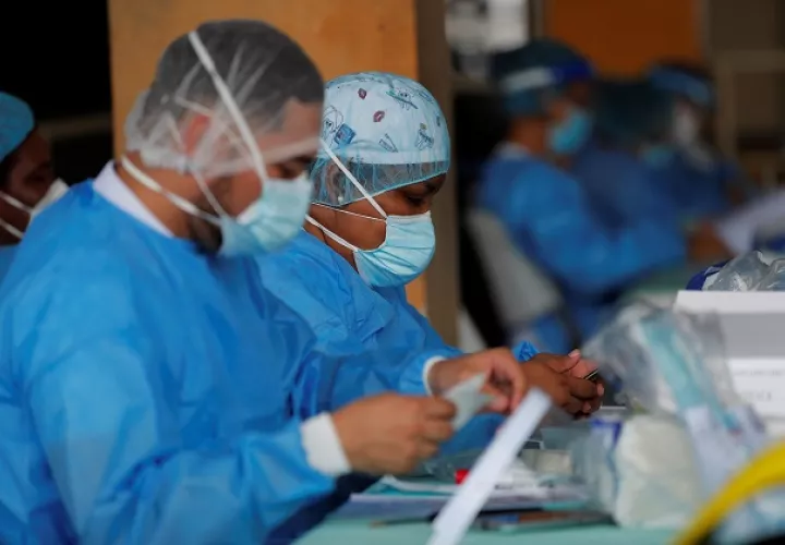 Personal médico del Minsa manipula una prueba de hisopado nasal para detectar la COVID-19 en un puesto médico en el distrito de San Miguelito. Foto: EFE