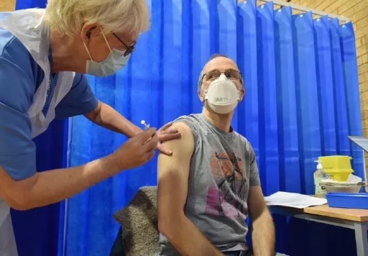 David Farrell, paciente de 51 años, recibe una de las dos vacunas de Pfizer y BioNtech en un centro de vacunación en Cardiff (Reino Unido). EFE/Ben Birchal