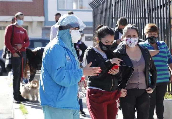 Personal médico organiza una fila de personas que se van tomar pruebas de covid-19
