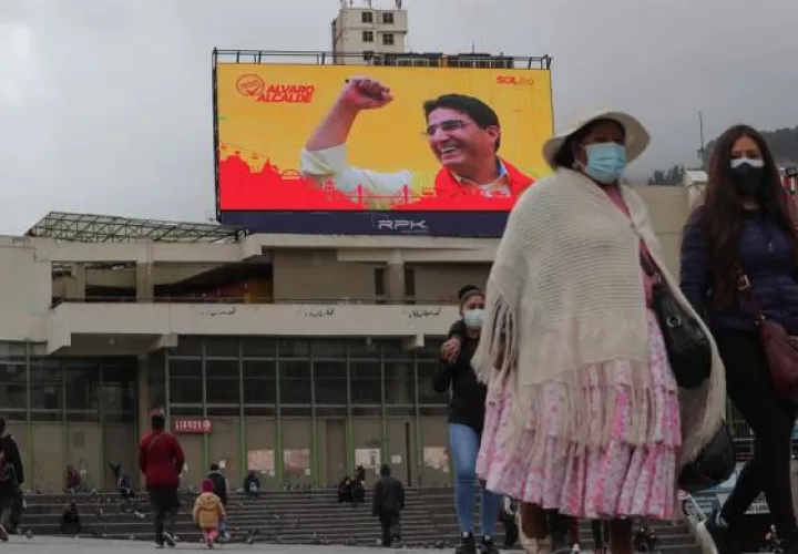 Varias personas frente a una pantalla gigante de publicidad electoral, el jueves 4 de febrero de 2021, en La Paz