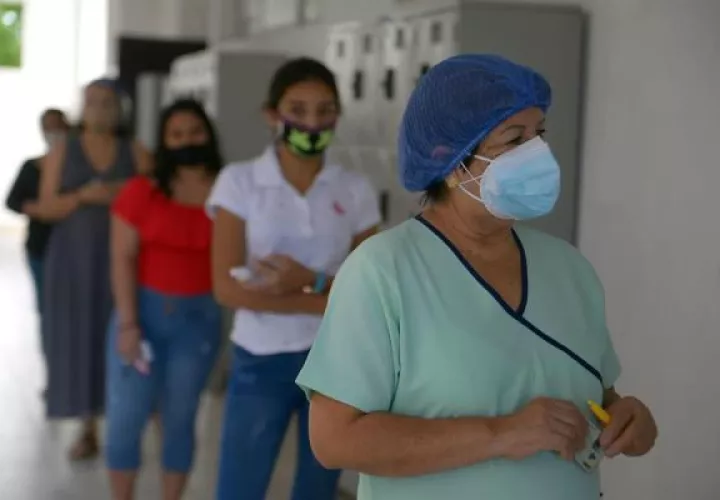 Mujeres esperan en fila para votar hoy, en un centro electoral en Guayaquil 