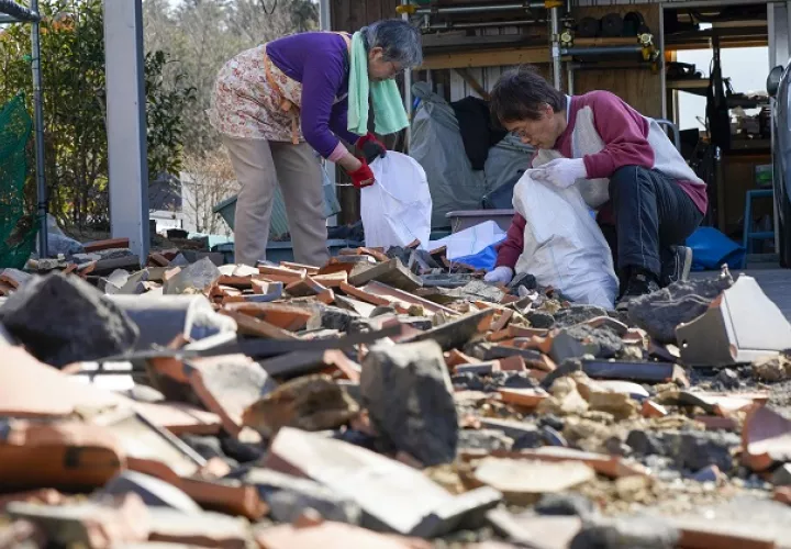 Residentes recogen tejas dañadas que se rompieron por un poderoso terremoto de magnitud 7,3 en Soma, Prefectura de Fukushima, al norte de Japón. Foto: EFE