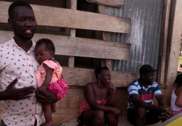 Un padre haitiano carga a su hija de cuatro meses en la comunidad de Bajo Chiquito, luego de realizar la caminata por el Tapón del Darién. Víctor Arosemena 
