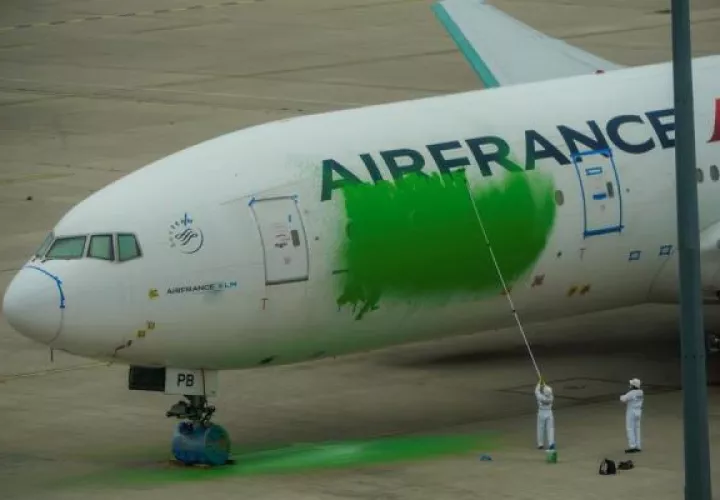 Activistas de Greenpeace pintan de verde un avión de Air France en el aeropuerto Charles de Gaulle para reclamar una reducción de vuelos.