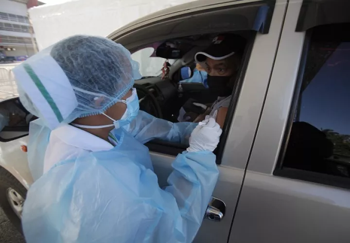 Enfermeras aplican la primera dosis de la vacuna  de Pfizer a adultos mayores de 60 años en sus automóviles en el centro de Vacunación Express, en los estacionamientos del Estadio Rommel Fernández Gutiérrez, en Juan Díaz. Foto. EFE