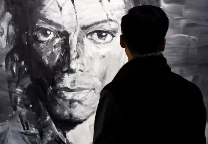 Un visitante observa las obras del artista chino Yan Pei-Ming de Michael Jackson. EFE