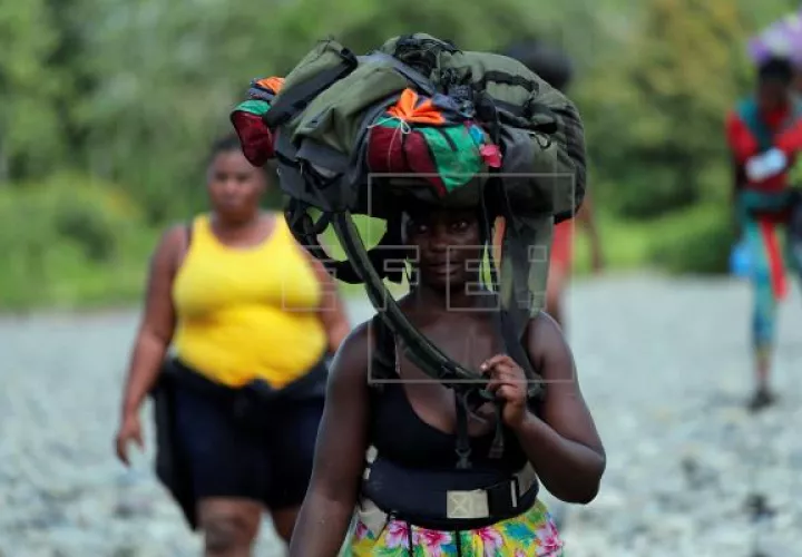 Una mujer migrante llega con su mochila en la cabeza, el 10 de febrero de 2021, a la comunidad de Bajo Chiquito, provincia del Darién (Panamá). Foto: EFE